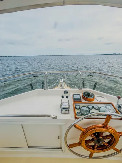 Mystic Yacht Photos Pics 1989 Grand Banks 36 Sedan helm with wooden wheel, overlooking calm ocean waters.