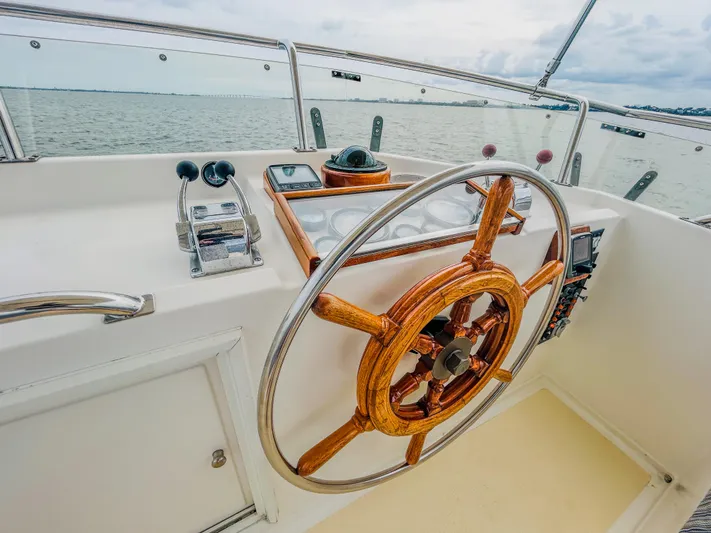 Mystic Yacht Photos Pics Helm of 1989 Grand Banks 36 Sedan with wooden steering wheel, overlooking the sea.