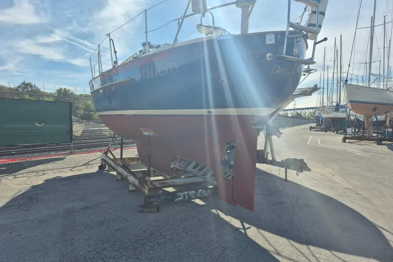 Felicity Yacht Photos Pics 1997 Pacific Seacraft 34 sailboat on dry dock, sunlight streaming, marina background.