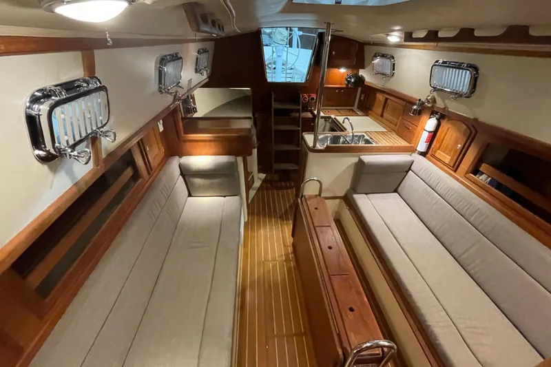 Felicity Yacht Photos Pics Interior of 1997 Pacific Seacraft 34 sailboat with wooden finishes and cozy seating.