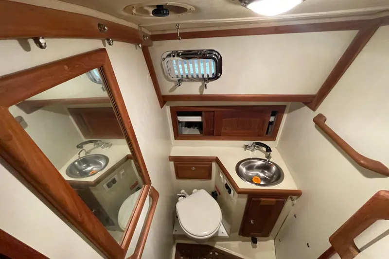 Felicity Yacht Photos Pics Bathroom interior of 1997 Pacific Seacraft 34 yacht with sink, toilet, and wooden accents.