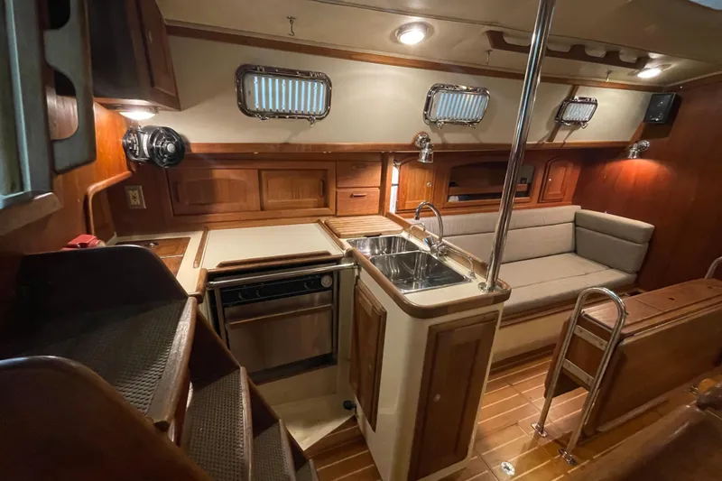 Felicity Yacht Photos Pics Interior of 1997 Pacific Seacraft 34 sailboat with wood finish and compact kitchen.
