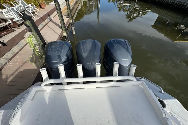  Yacht Photos Pics 2009 Venture 39 Center Console with triple outboard engines docked by a wooden pier.