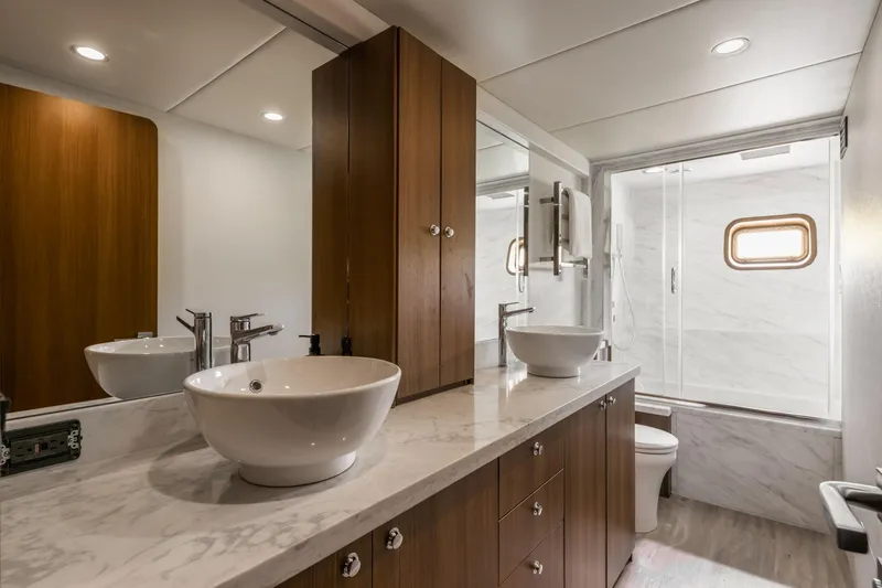  Yacht Photos Pics Luxurious yacht bathroom with marble countertop, vessel sinks, and wooden cabinetry, Primorets Custom 2010 model.