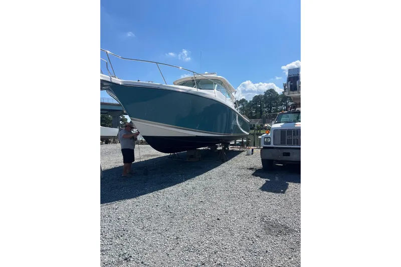  Yacht Photos Pics 2016 Pursuit OS 385 Offshore boat on dry dock under clear blue sky.