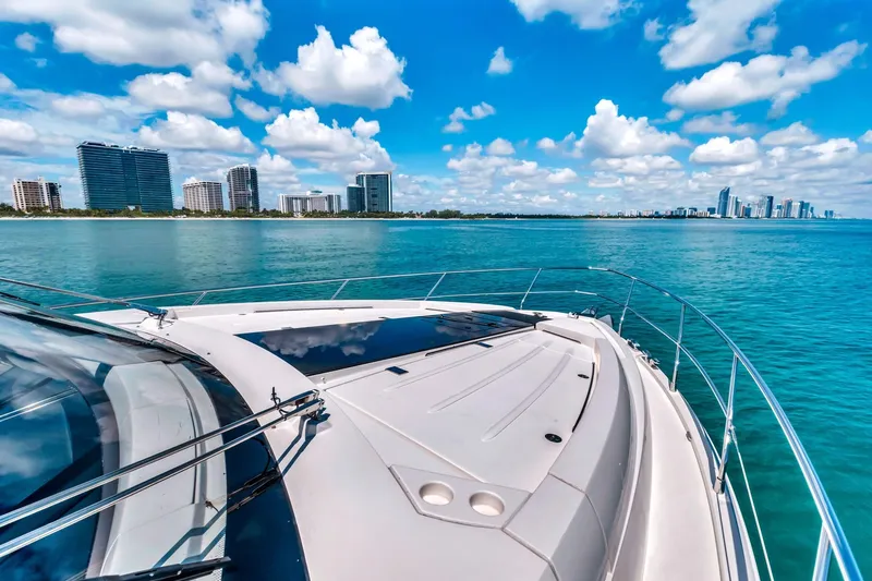 Karisa Yacht Photos Pics 2018 Fairline Targa 53 OPEN yacht cruising near city skyline under blue sky.