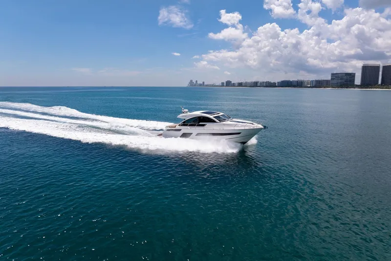 Karisa Yacht Photos Pics 2018 Fairline Targa 53 OPEN yacht cruising on clear blue ocean near city skyline.