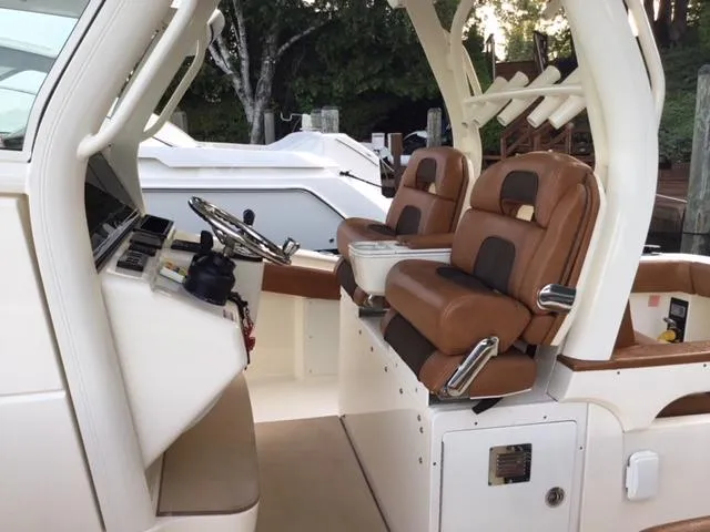  Yacht Photos Pics 2016 Scout 350 LXF boat interior with brown leather seats and steering console.