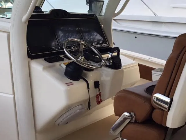  Yacht Photos Pics Helm of 2016 Scout 350 LXF boat with steering wheel and brown seat.