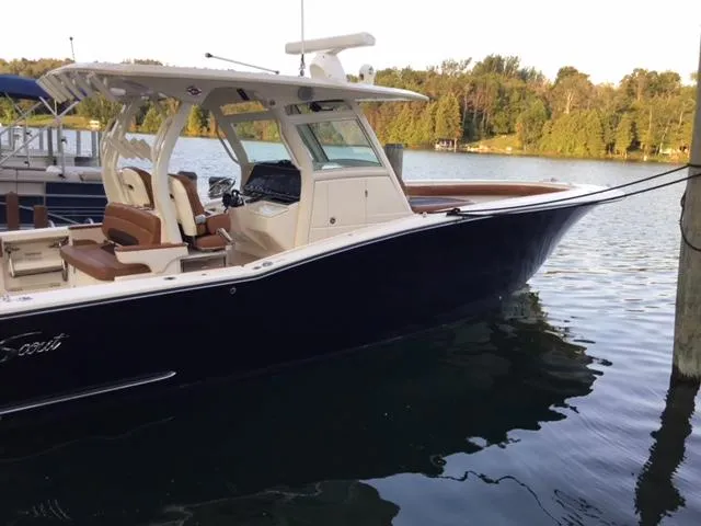  Yacht Photos Pics 2016 Scout 350 LXF boat docked on a serene lake with lush greenery.