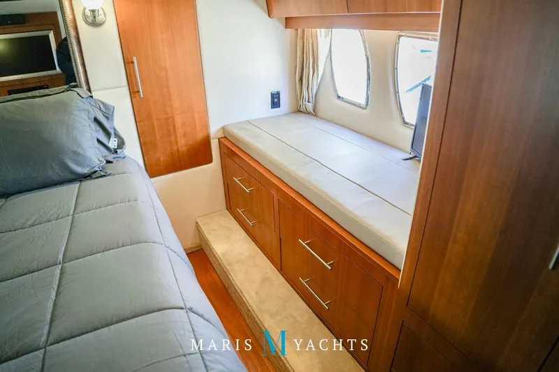  Yacht Photos Pics Interior of 2009 Regal 52 Sport Coupe yacht with wooden cabinetry and cozy bedding.
