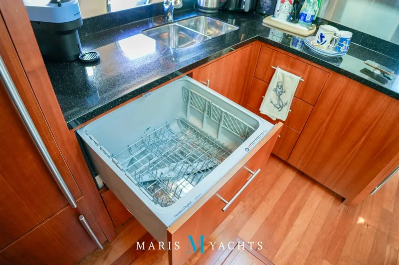  Yacht Photos Pics Open dishwasher in 2009 Regal 52 Sport Coupe yacht kitchen with wooden cabinetry.