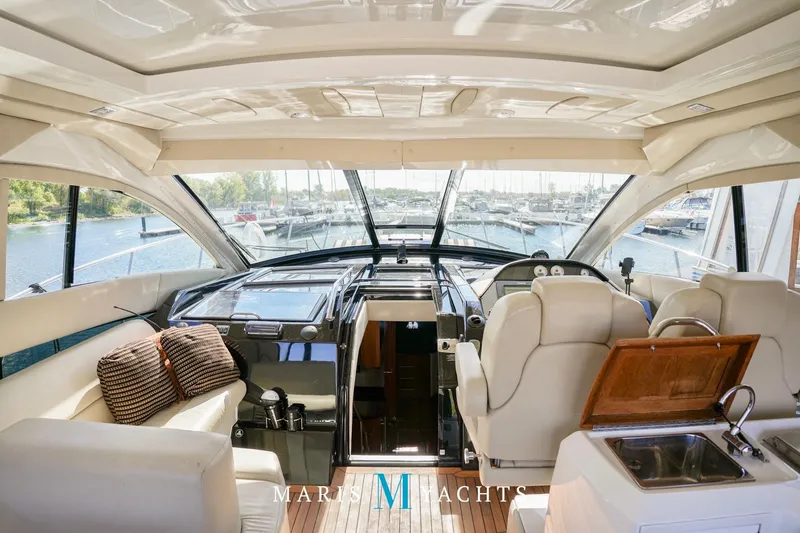  Yacht Photos Pics Luxurious interior of 2009 Regal 52 Sport Coupe yacht with panoramic windows and plush seating.