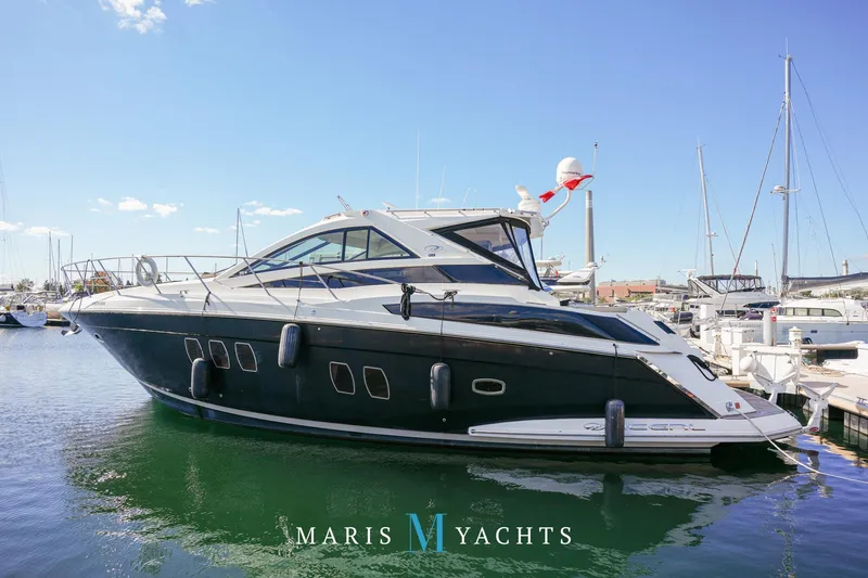  Yacht Photos Pics 2009 Regal 52 Sport Coupe yacht docked in a marina under clear blue skies.
