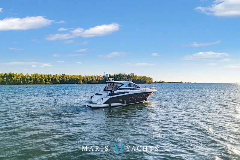  Yacht Photos Pics 2009 Regal 52 Sport Coupe yacht cruising on a serene lake under a clear blue sky.