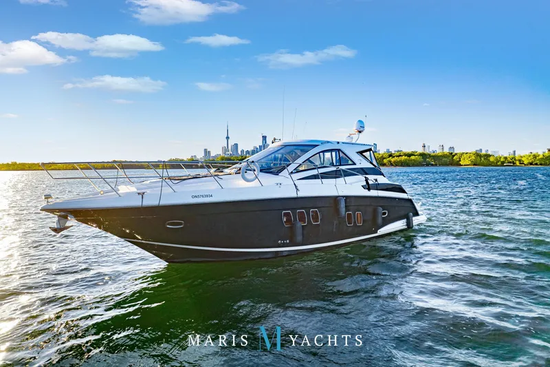  Yacht Photos Pics 2009 Regal 52 Sport Coupe yacht on water with city skyline in background.