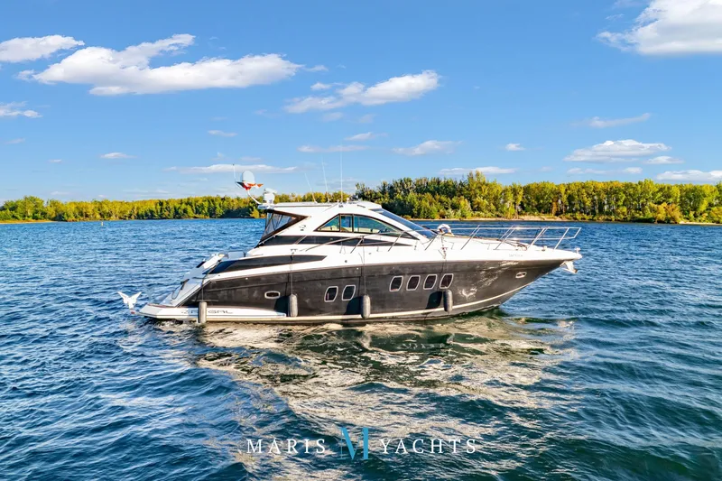  Yacht Photos Pics 2009 Regal 52 Sport Coupe yacht cruising on a sunny lake with scenic forest backdrop.