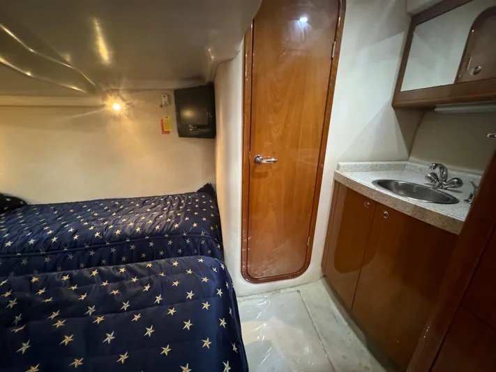 Aquaholics Yacht Photos Pics 2008 Regal Commodore 4460 cabin with twin beds, wooden door, and compact sink area.