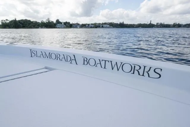  Yacht Photos Pics 2024 Islamorada Boatworks 24 on calm water, showcasing sleek design and branding.