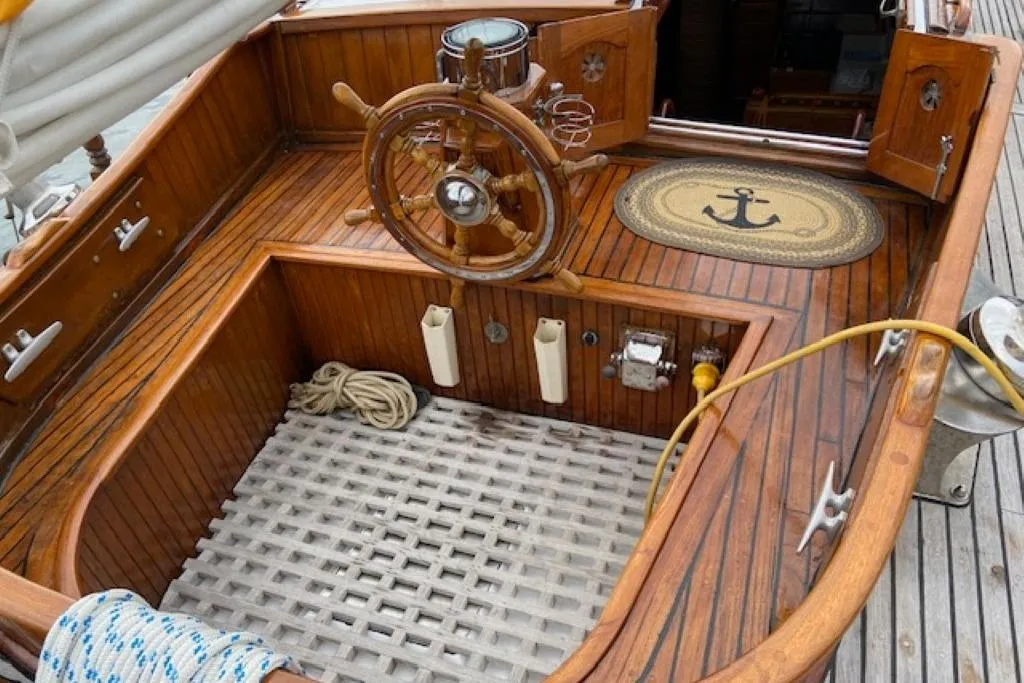 Wooden deck of 1966 Allen Mackay Gaff rigged top sail schooner with ship's wheel.
