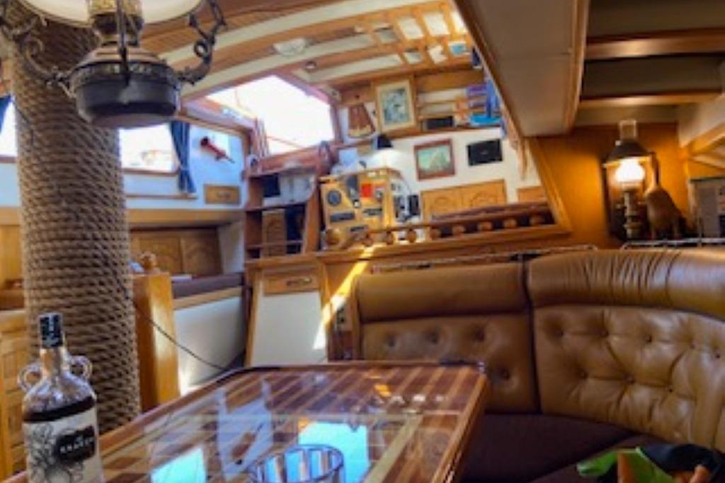 Interior of 1966 Allen MacKay Schooner 53, featuring wooden decor and cozy seating area.