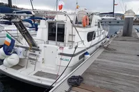 1996 Nimbus Trawler 37 docked at marina with flags and lifebuoys.