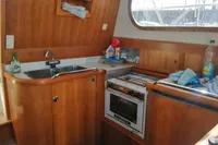 Wooden kitchen interior of 1996 Nimbus Trawler 37 with sink, stove, and window.