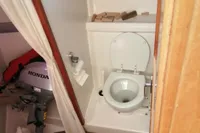 Nimbus Trawler 37 (1996) bathroom with toilet, wooden flooring, and storage shelves.