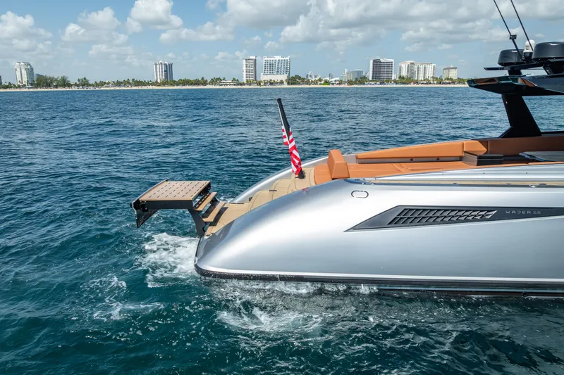Why Her Yacht Photos Pics 2024 Wajer 55 HT yacht cruising near city skyline, featuring sleek design and American flag.