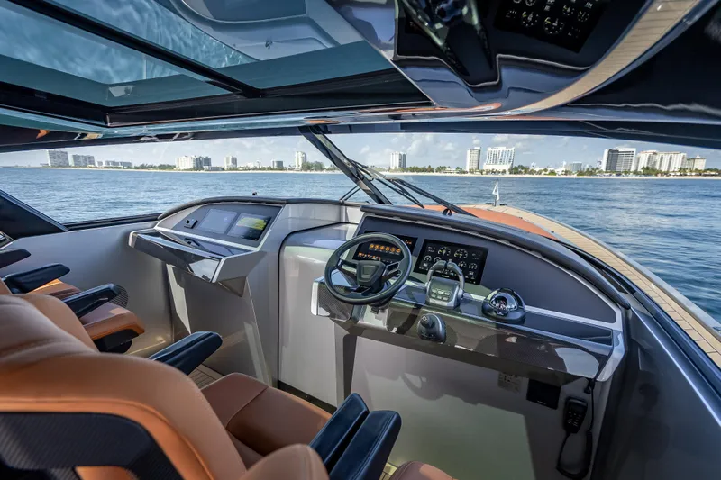Why Her Yacht Photos Pics Luxurious 2024 Wajer 55 HT yacht cockpit with modern controls, overlooking a coastal cityscape.