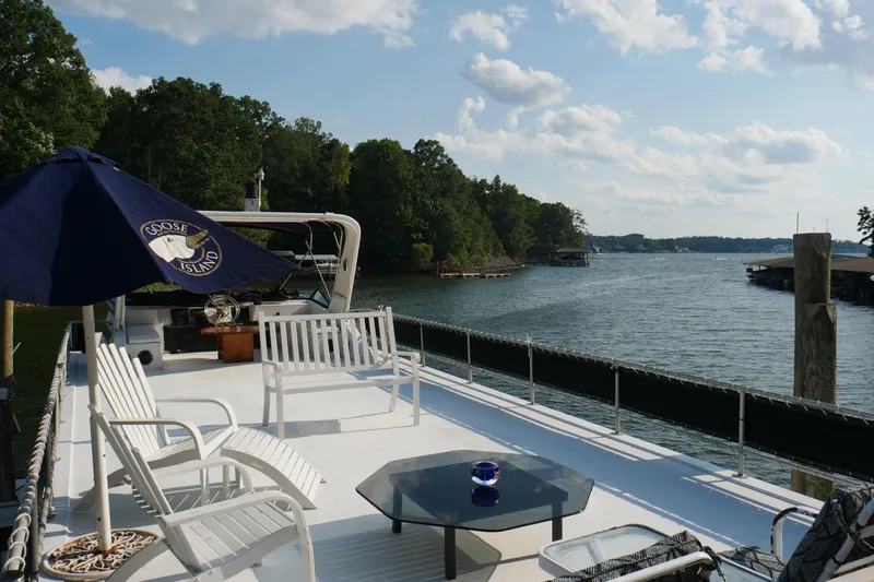  Yacht Photos Pics Deck of 1996 STARDUST Cruiser with seating, umbrella, and scenic lake view.