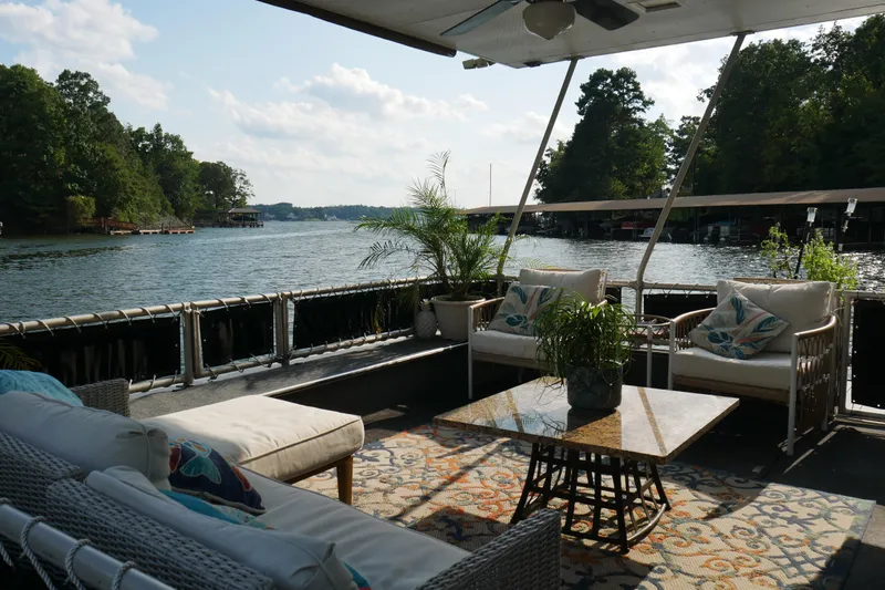  Yacht Photos Pics Luxurious 1996 STARDUST Cruiser houseboat with elegant outdoor seating and scenic lake view.
