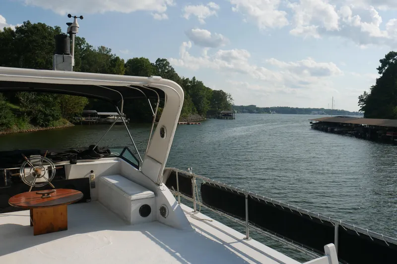  Yacht Photos Pics 1996 STARDUST Cruiser boat on a serene lake with lush green surroundings.