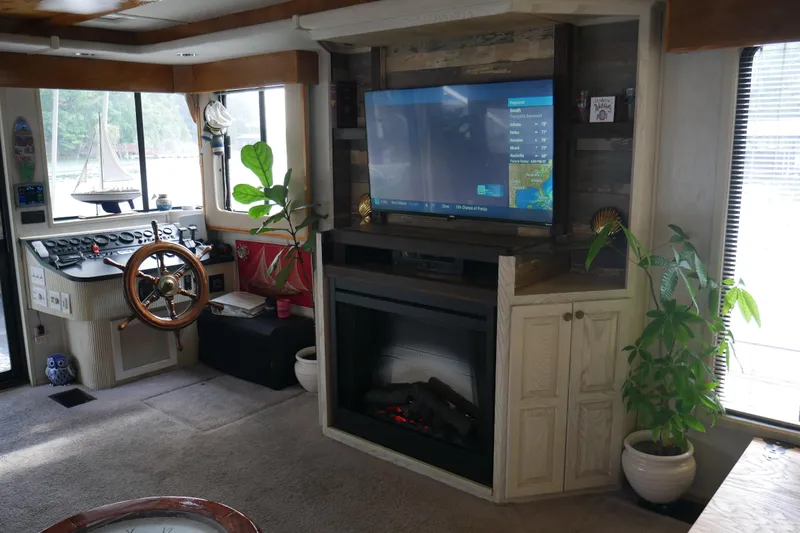  Yacht Photos Pics Interior of 1996 STARDUST Cruiser with helm, fireplace, and plants. Cozy and nautical design.