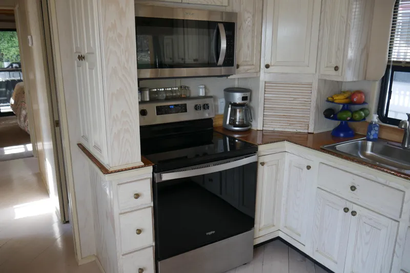  Yacht Photos Pics 1996 STARDUST Cruiser kitchen with modern appliances and white cabinetry.