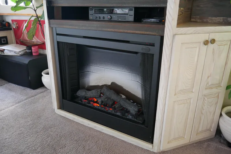  Yacht Photos Pics Electric fireplace in a 1996 STARDUST Cruiser, featuring realistic logs and cozy ambiance.