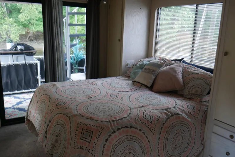  Yacht Photos Pics Cozy bedroom in 1996 STARDUST Cruiser with patterned bedding and outdoor view.