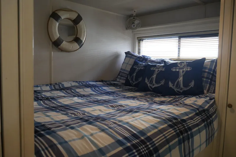  Yacht Photos Pics Cozy bedroom in 1996 STARDUST Cruiser with nautical-themed decor and plaid bedding.