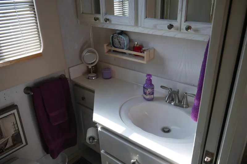  Yacht Photos Pics Bathroom in 1996 STARDUST Cruiser with sink, mirror, and purple towel.