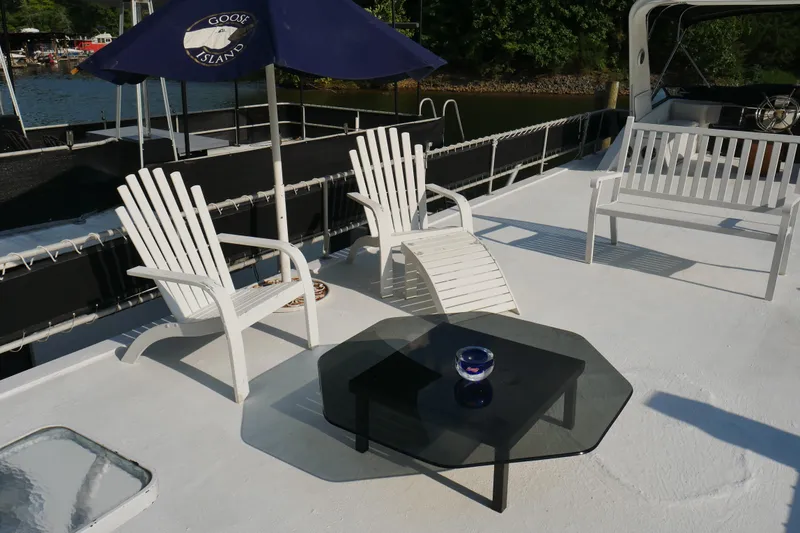  Yacht Photos Pics Deck of 1996 STARDUST Cruiser with white chairs, table, and umbrella.