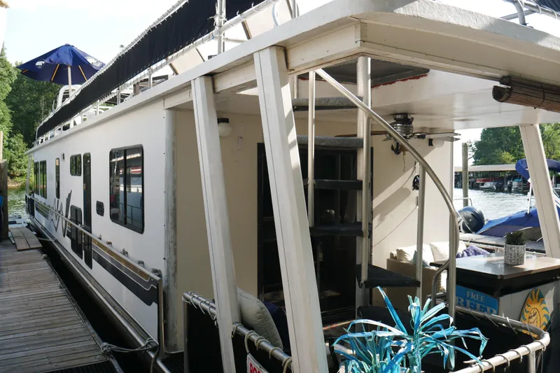  Yacht Photos Pics 1996 STARDUST Cruiser houseboat docked with outdoor seating and spiral staircase.