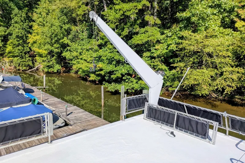  Yacht Photos Pics 1996 Stardust Cruisers boat docked by a lush, green riverside.