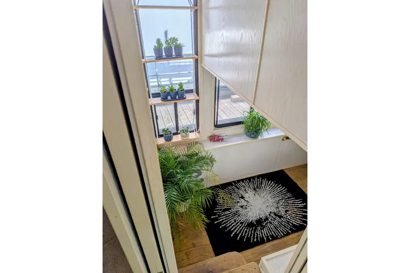  Yacht Photos Pics Interior of 1996 Stardust Cruiser with plants, decorative rug, and natural light.