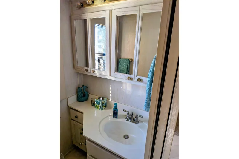  Yacht Photos Pics Bathroom vanity in 1996 Stardust Cruisers, featuring mirror cabinets and modern fixtures.