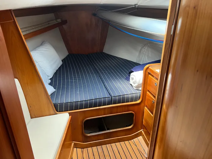 Tern Yacht Photos Pics Cozy cabin interior of 2001 J Boats J/120 with striped bedding and wooden finish.