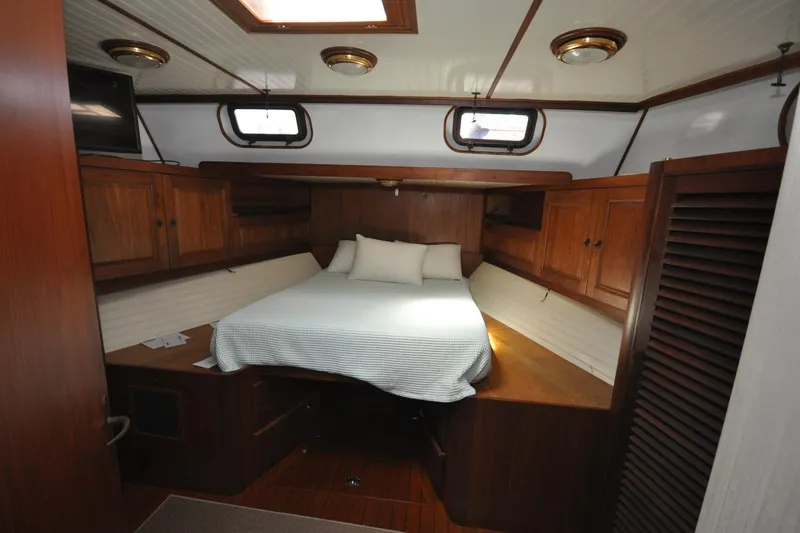 In The Flow Yacht Photos Pics Cozy cabin interior of 1982 Custom Virpack Steelhull with wooden furnishings and bed.