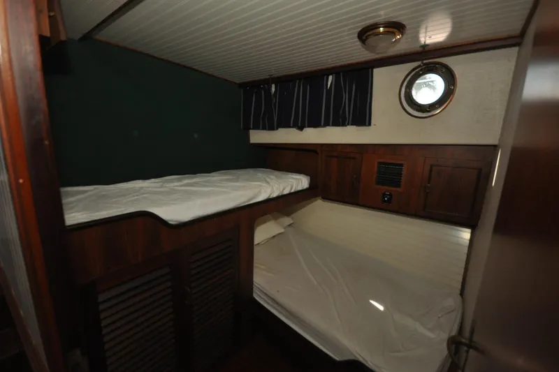 In The Flow Yacht Photos Pics Cozy cabin interior of 1982 Custom Virpack Steelhull with bunk beds and porthole.