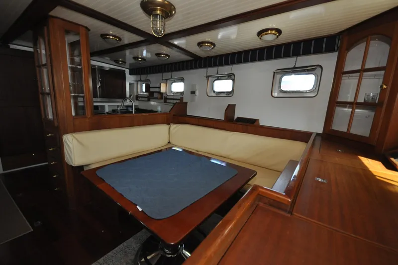 In The Flow Yacht Photos Pics Interior of 1982 Custom Virpack Steelhull yacht with wooden furnishings and cozy seating area.