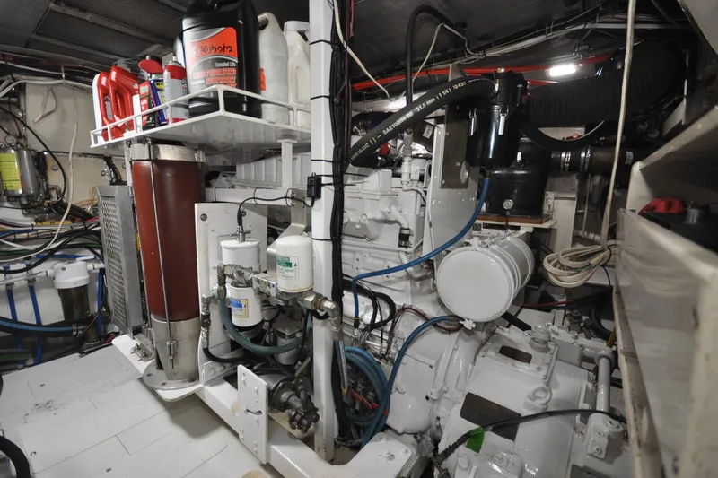 In The Flow Yacht Photos Pics Engine room of 1982 Custom Virpack Steelhull with various mechanical components and storage containers.
