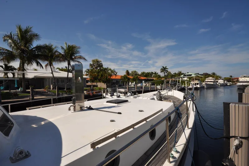 In The Flow Yacht Photos Pics Custom 1982 Virpack Steelhull yacht docked in a sunny marina with palm trees.
